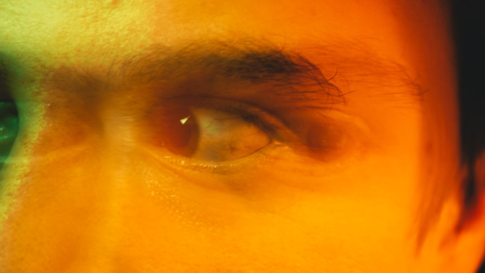 a close up of a man's eye with a blurry background