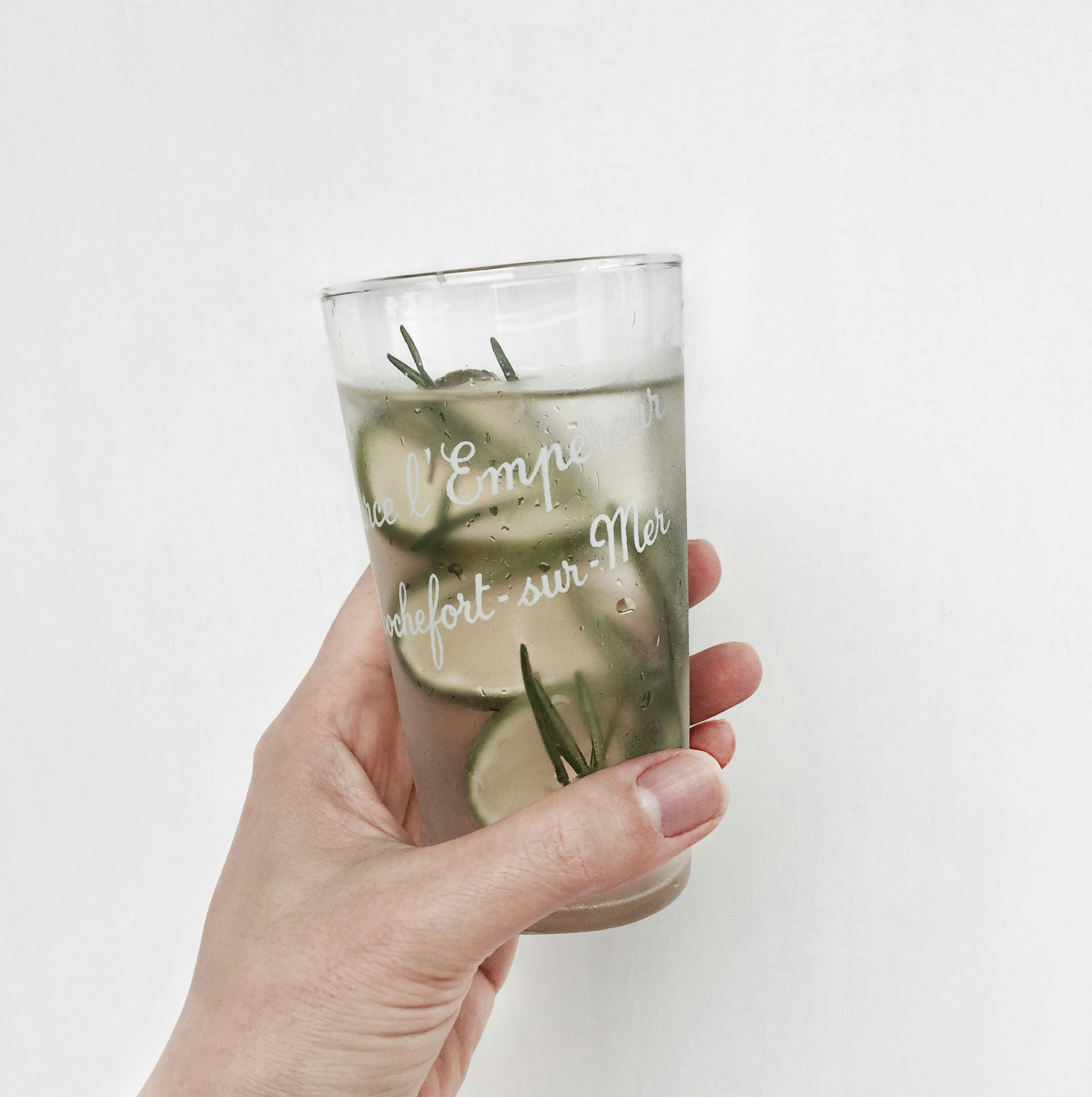 a person holding a glass with a liquid inside of it