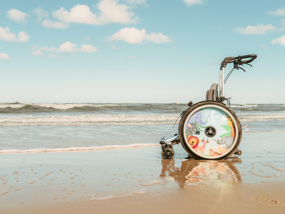 uma cadeira de rodas sentada em cima de uma praia de areia
