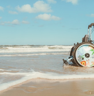 a beach scene with a electric wheelchair in the water