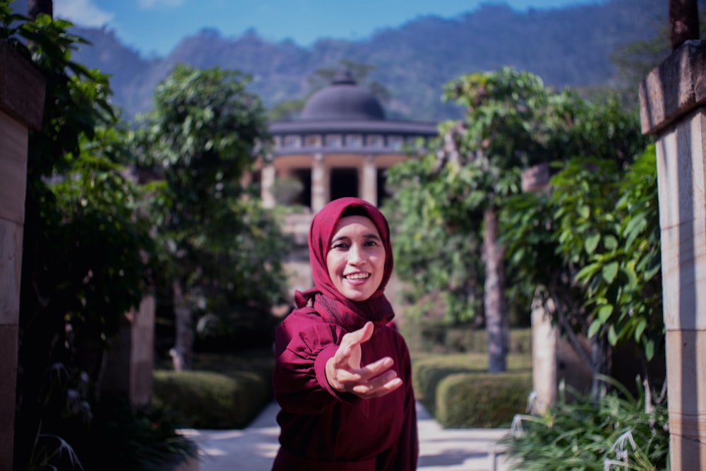 a woman in a red hijab standing in front of a building