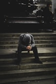 a man sitting on some steps with his head in his hands