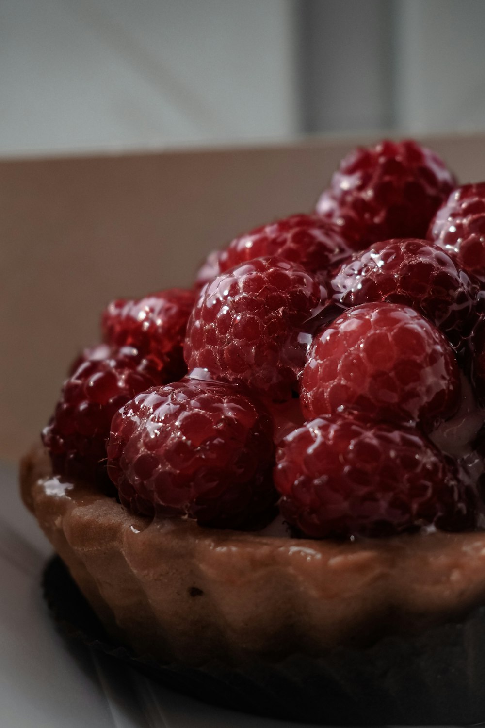 a close up of a bowl of raspberries on a table