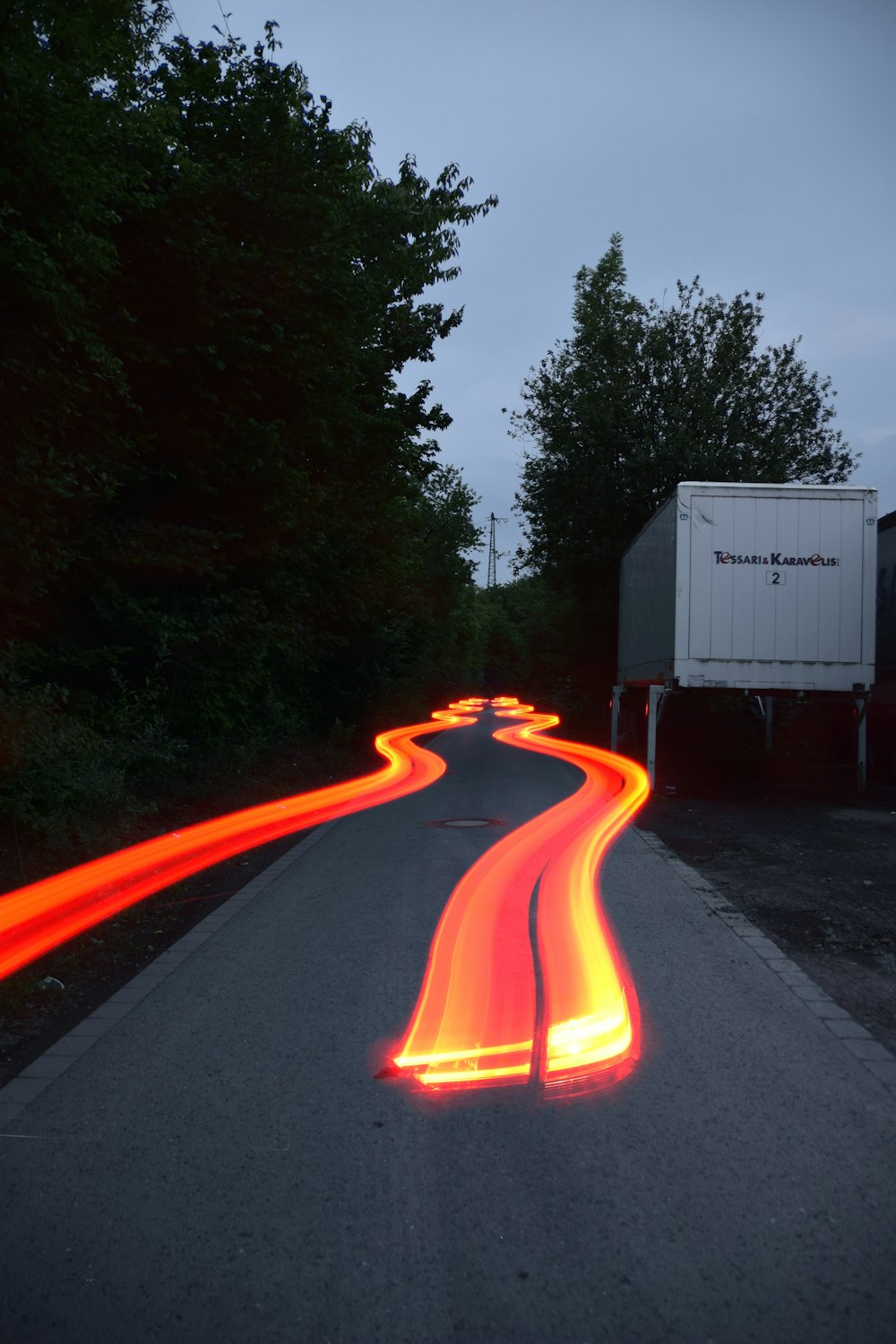 a long exposure photo of a road with red lights