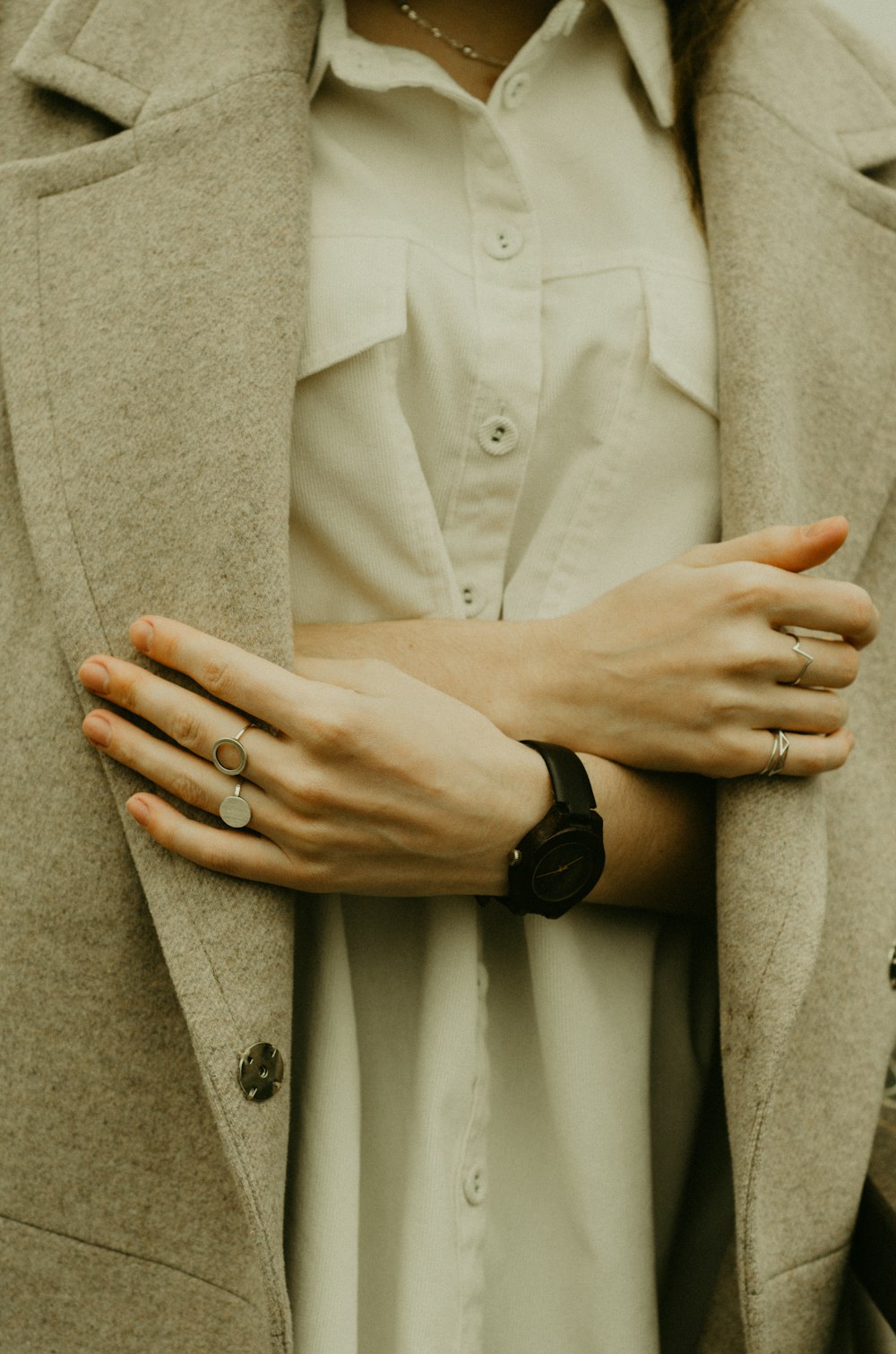 a woman wearing a white shirt and a beige coat