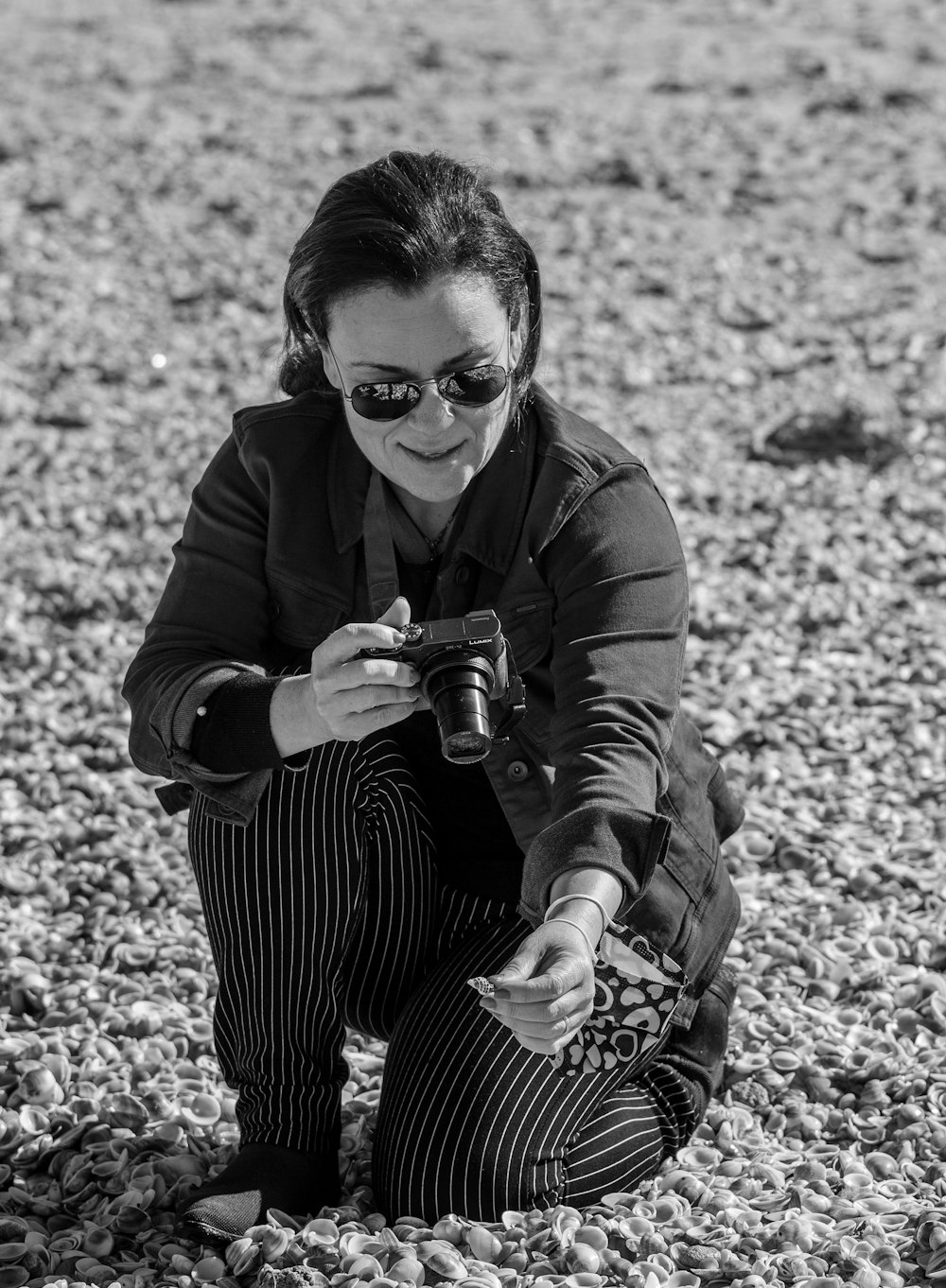 a woman kneeling down on a rocky beach