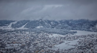 a snow covered mountain with a city below