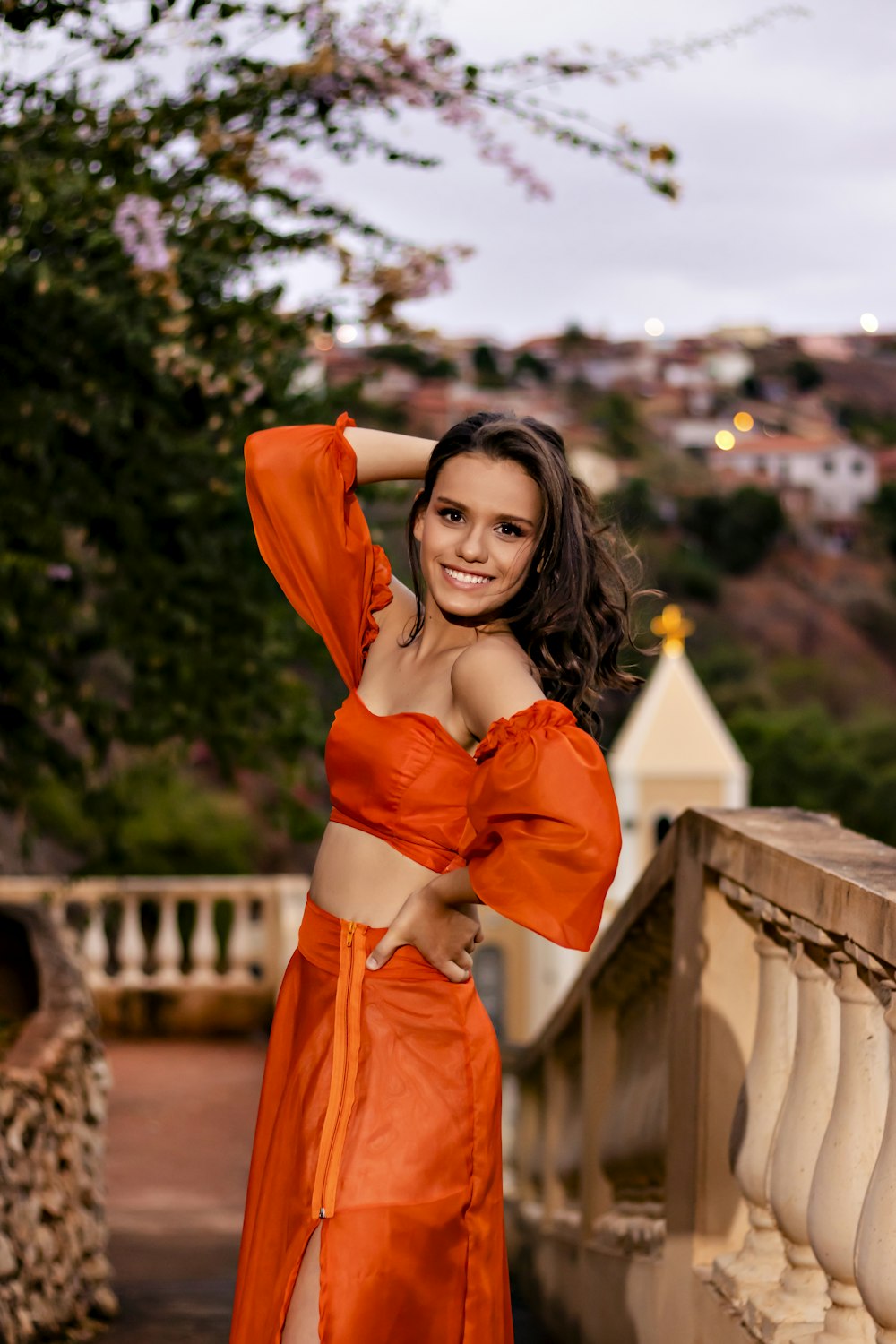 a woman in an orange dress posing for a picture