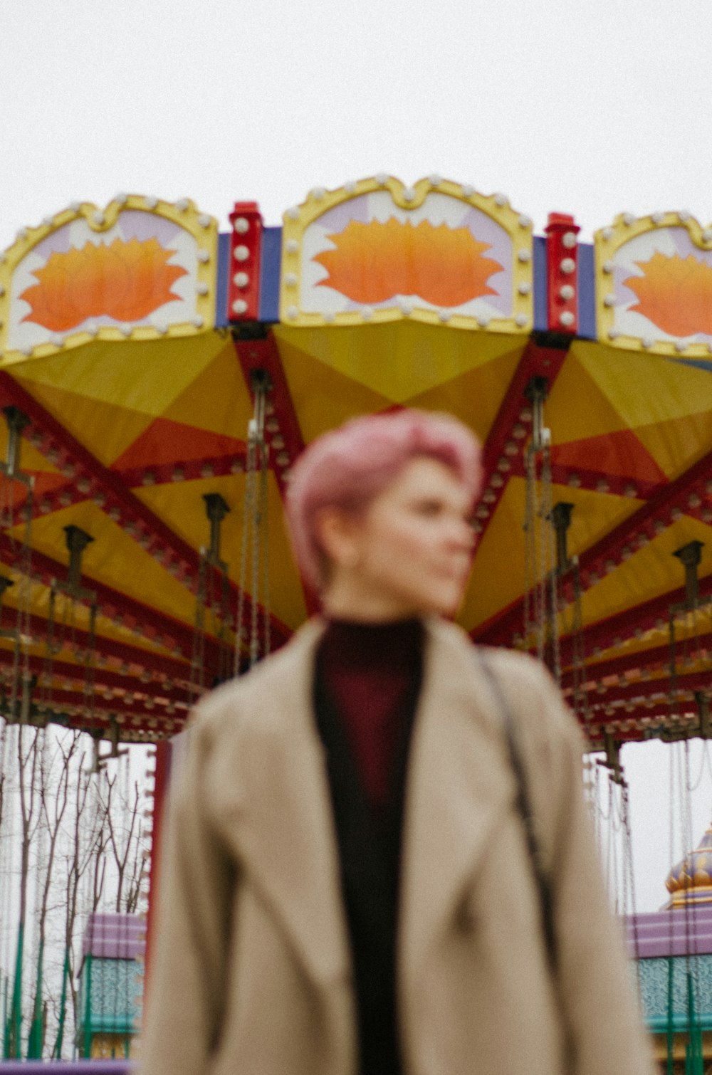 a woman standing in front of a carnival ride