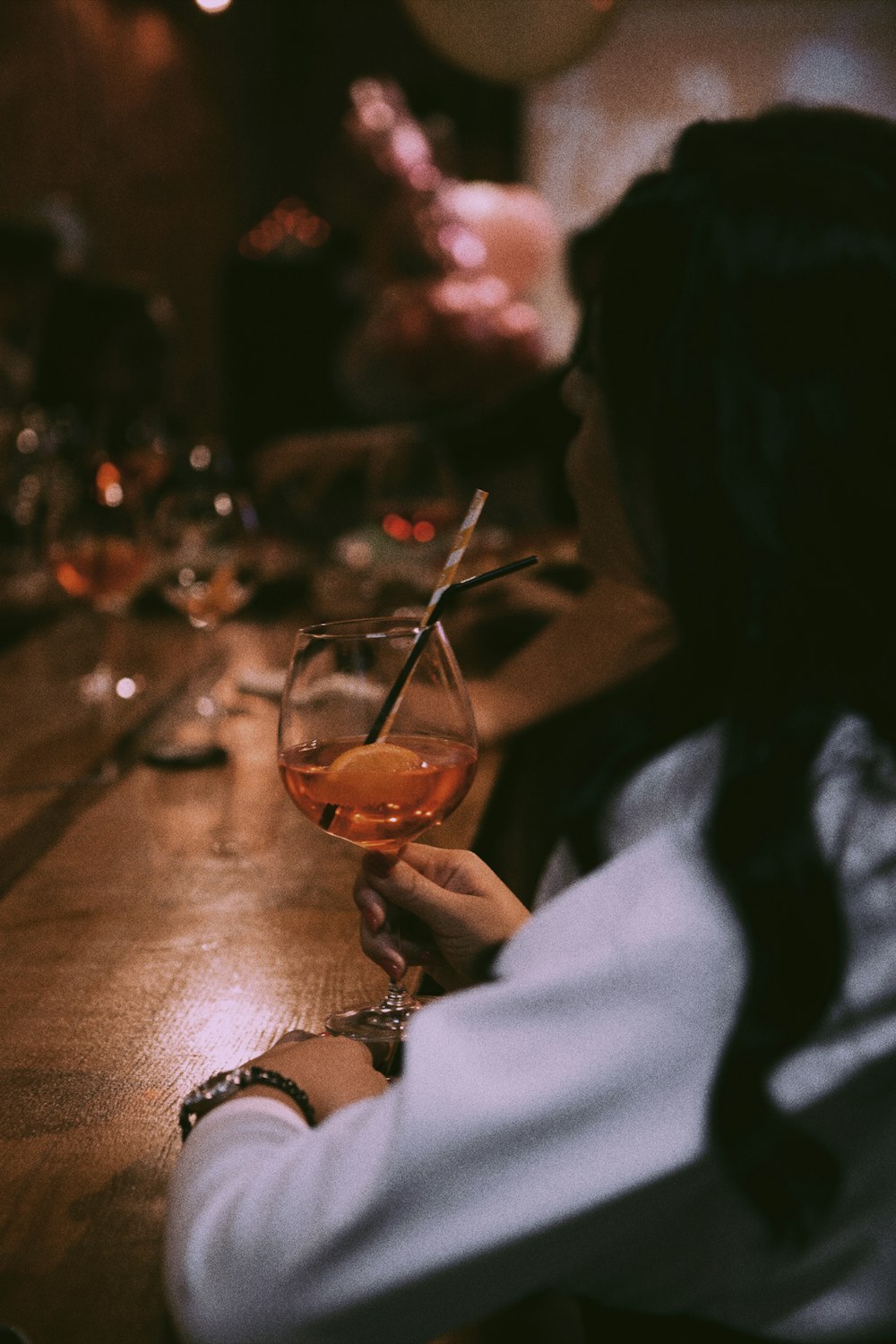 uma mulher sentada em um bar com um copo de vinho
