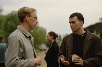 a couple of men standing next to each other giving support