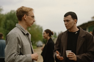 a couple of men standing next to each other giving support