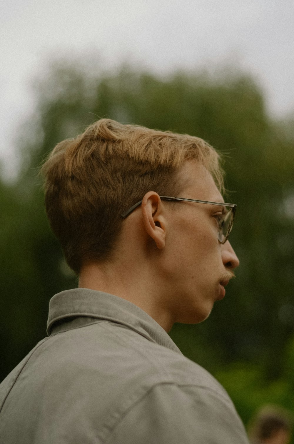 a man with glasses is looking away from the camera