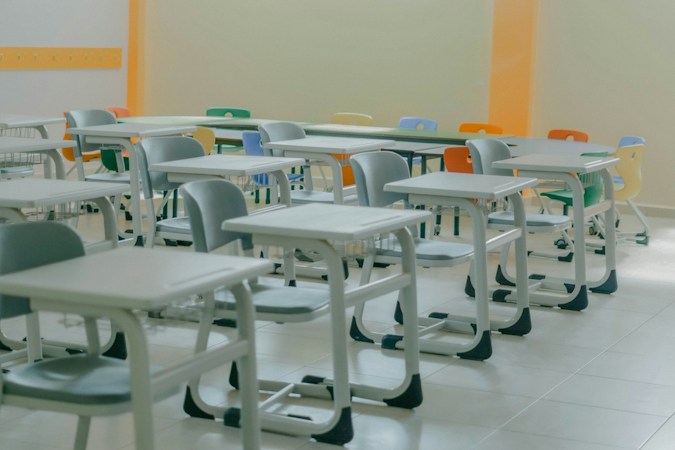 Students and desks in a bright high school classroom in session after a campus reopens