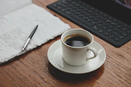 a cup of coffee sitting on top of a wooden table