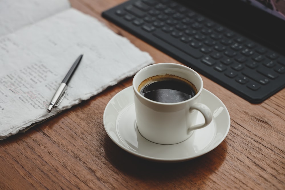 a cup of coffee sitting on top of a wooden table