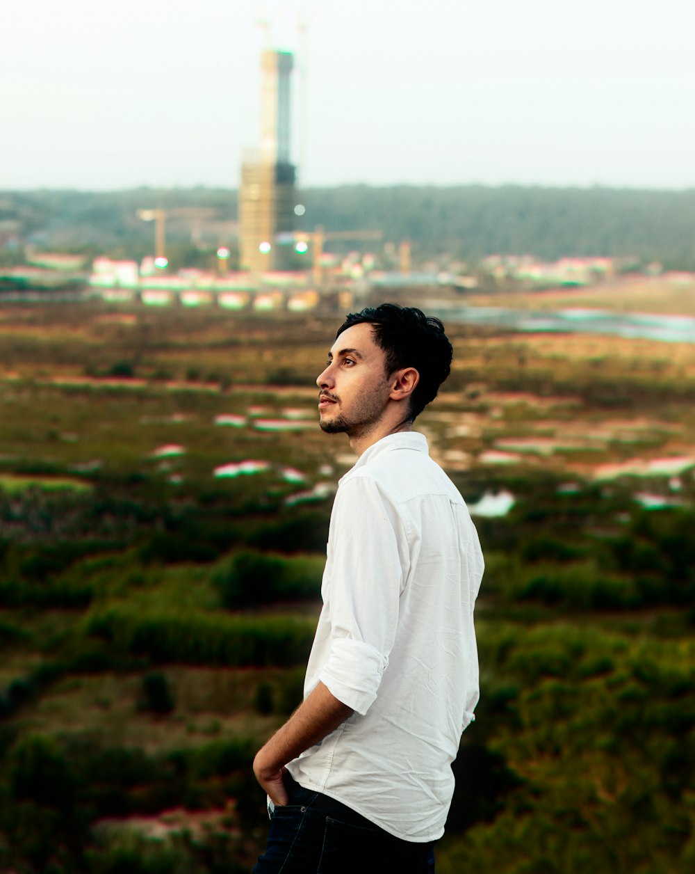 a man in a white shirt is standing on a hill