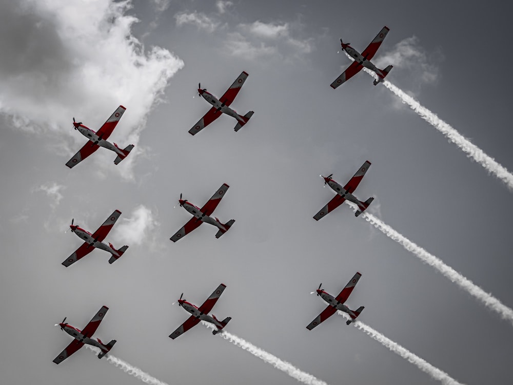 a group of planes flying through a cloudy sky