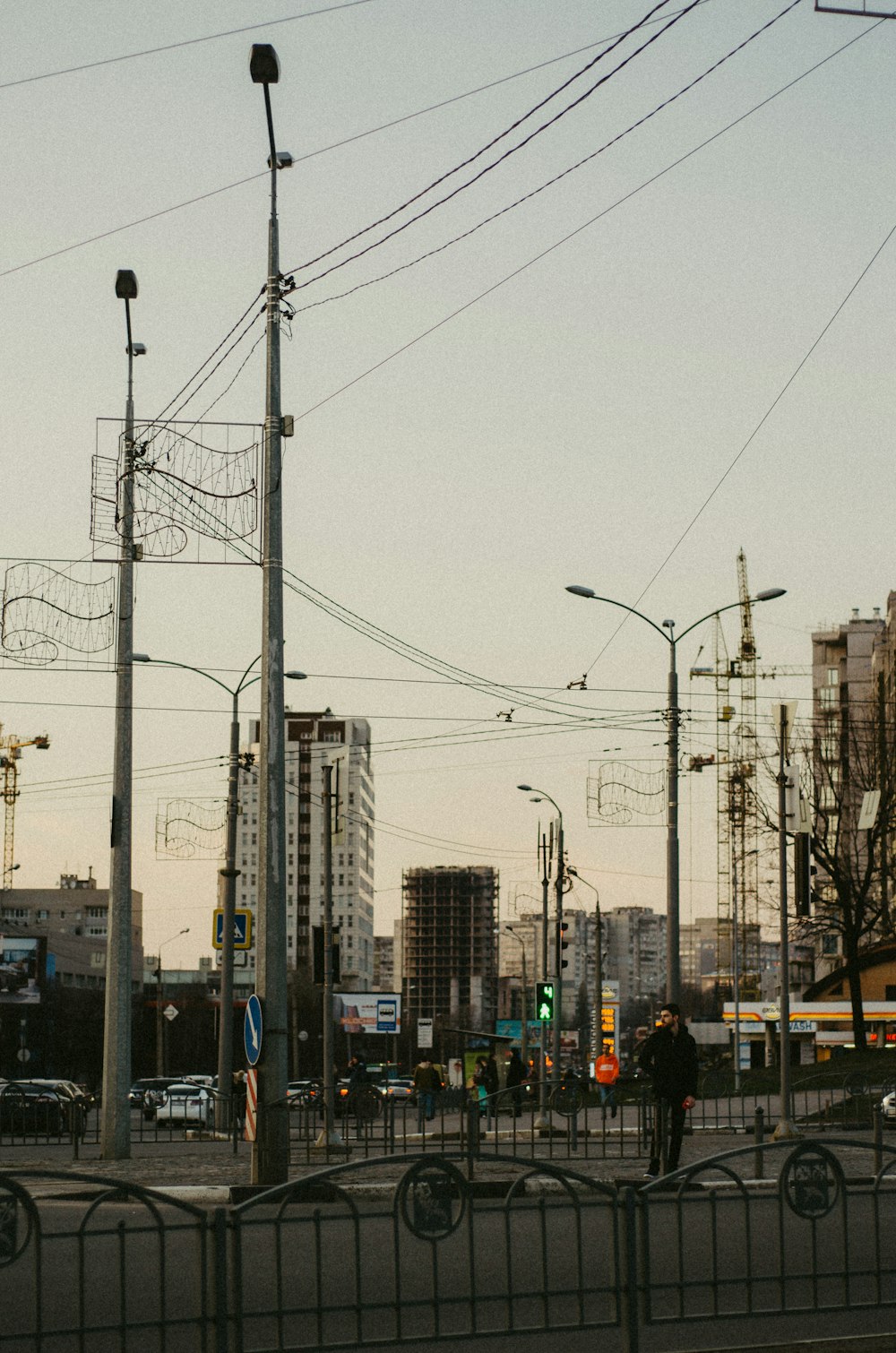 a group of people walking down a street next to tall buildings