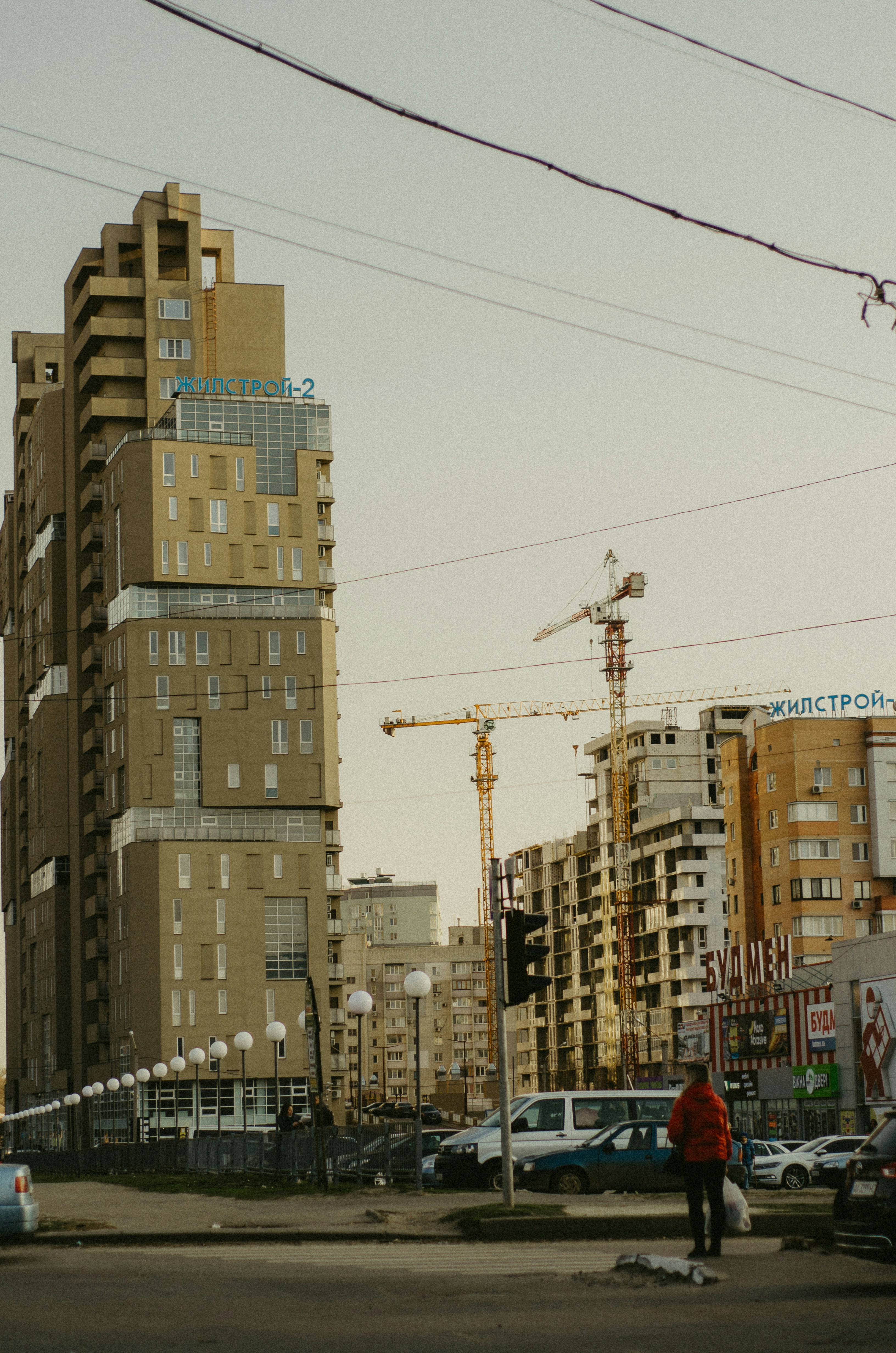 a man in a red jacket crossing a street