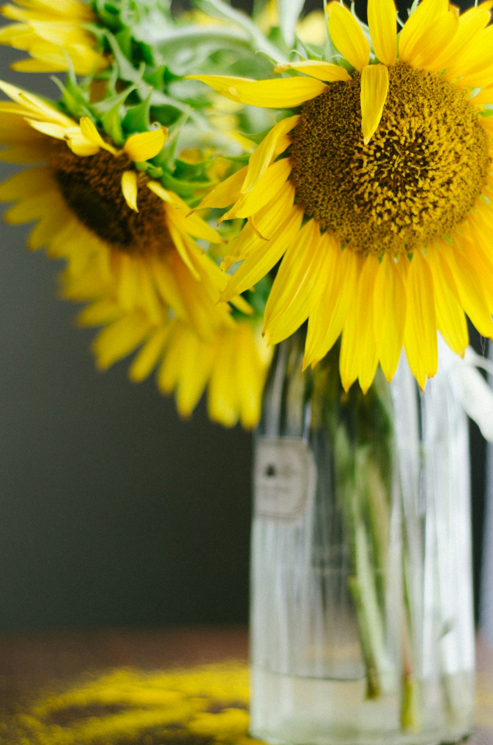 a vase filled with yellow sunflowers on top of a table