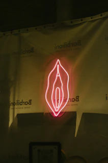 a red neon sign on the side of a wall