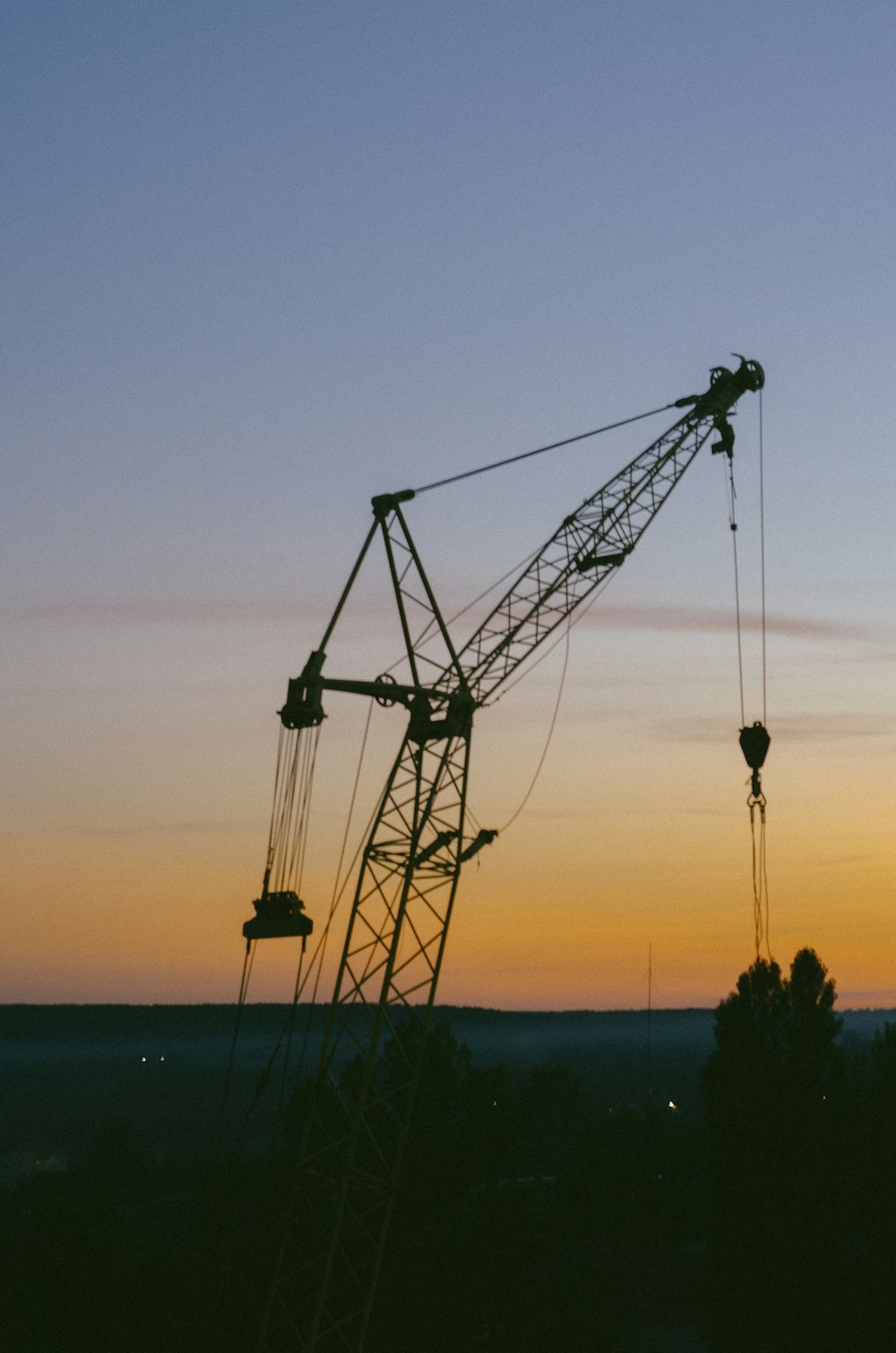 a crane is silhouetted against a sunset sky