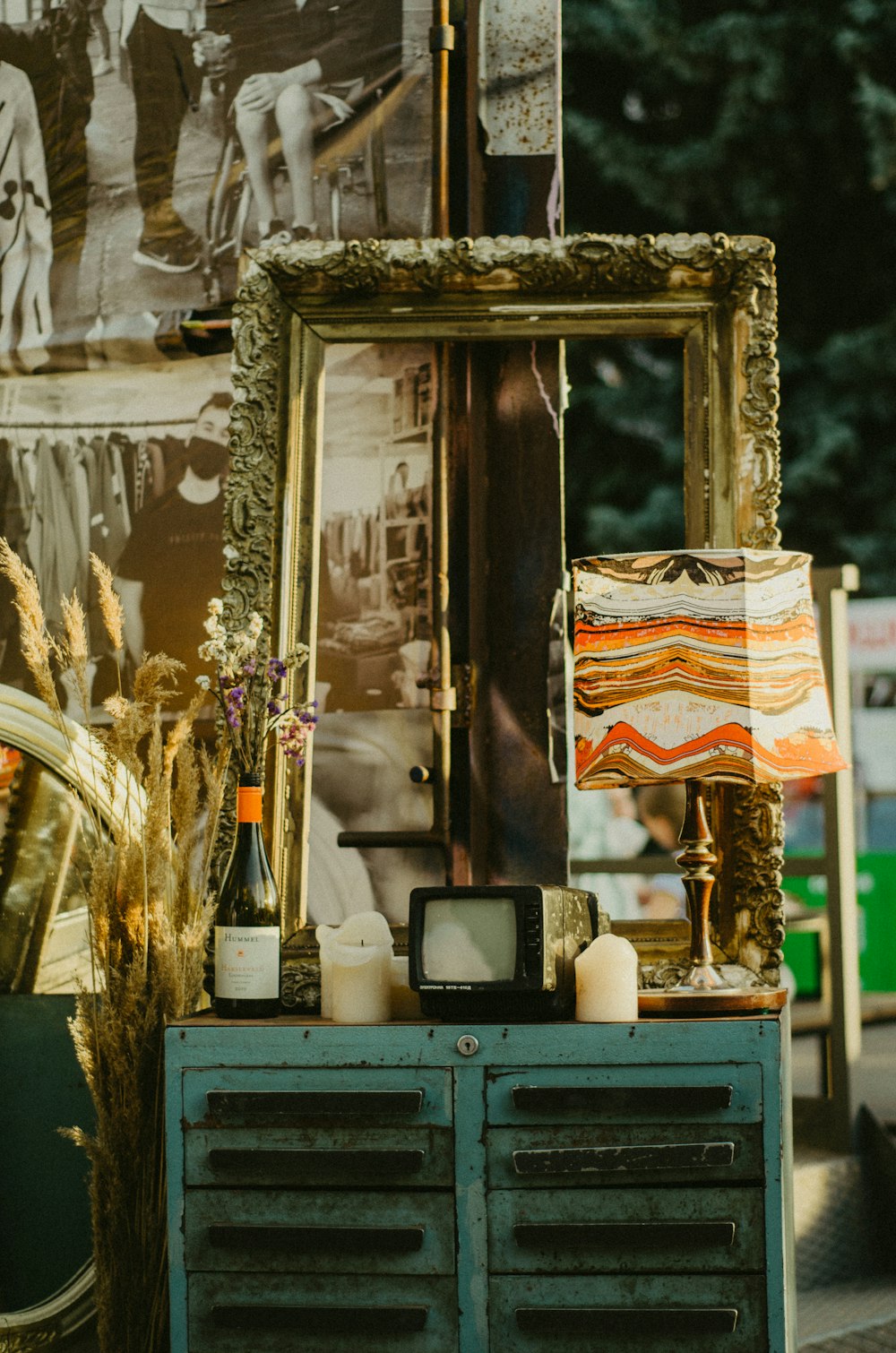 a cabinet with a lamp and a picture frame on top of it