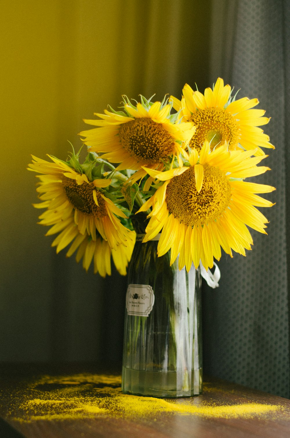 eine Vase gefüllt mit gelben Sonnenblumen auf einem Tisch