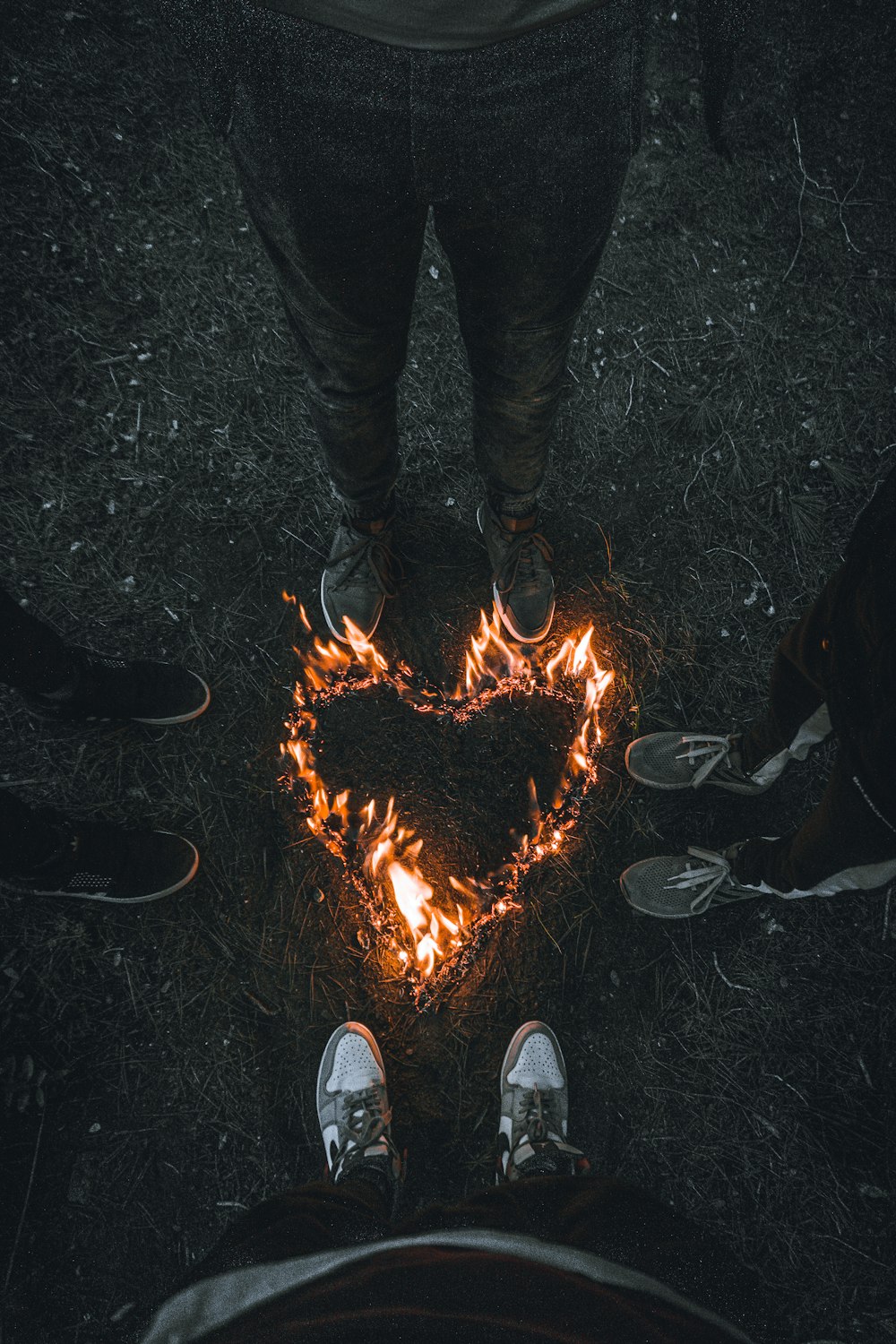 Una persona in piedi davanti a un cuore fatto di fuoco