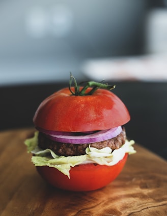 a hamburger with lettuce and tomato on a cutting board