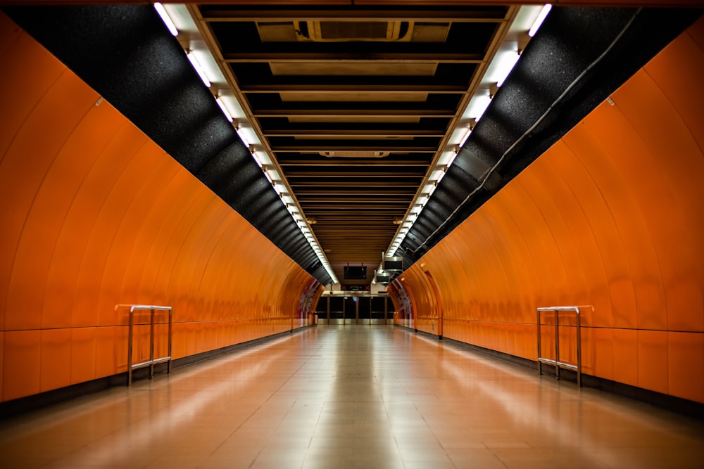 a long hallway with orange walls and metal railings