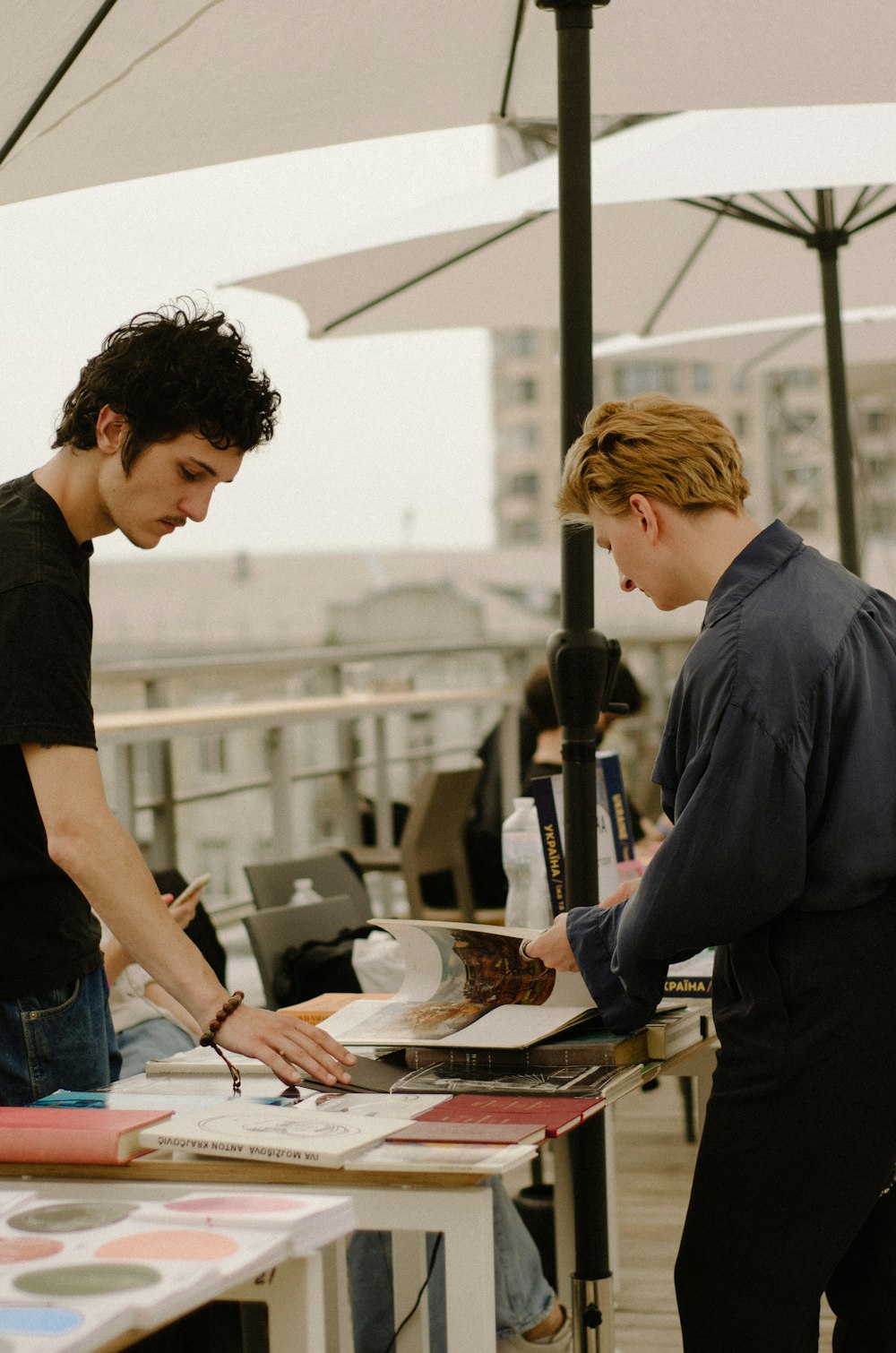 a couple of men standing next to each other at a table