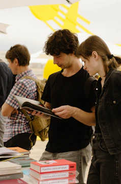 a man and a woman looking at a book