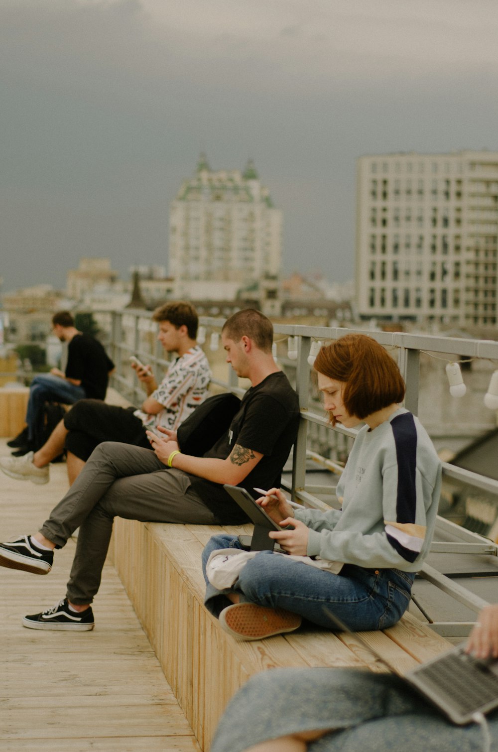 a group of people sitting on top of a wooden bench