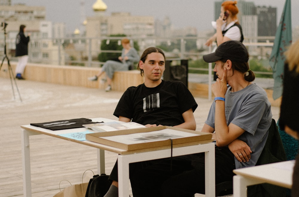 a man sitting at a table talking on a cell phone