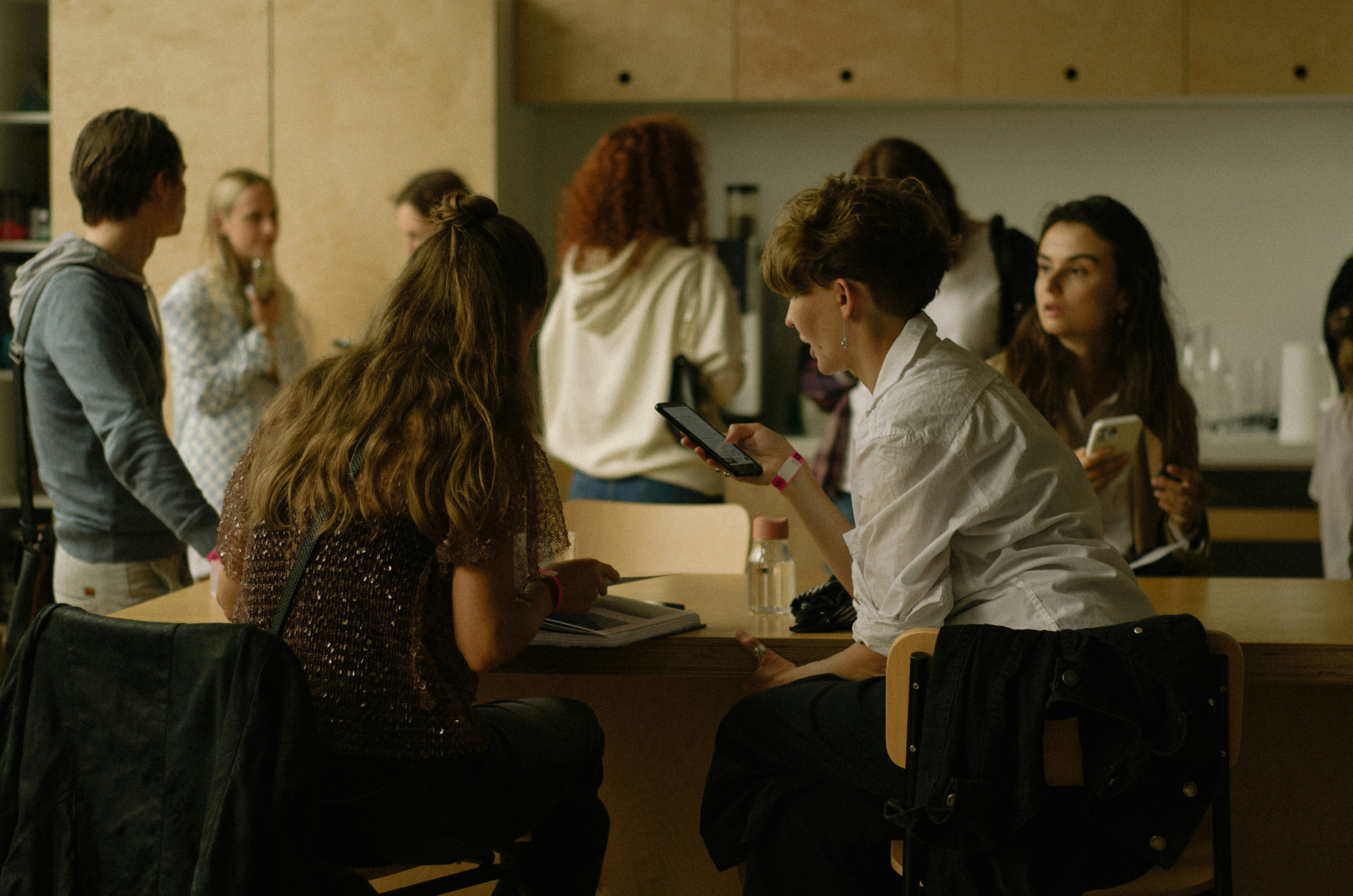 a group of people sitting at a table with cell phones