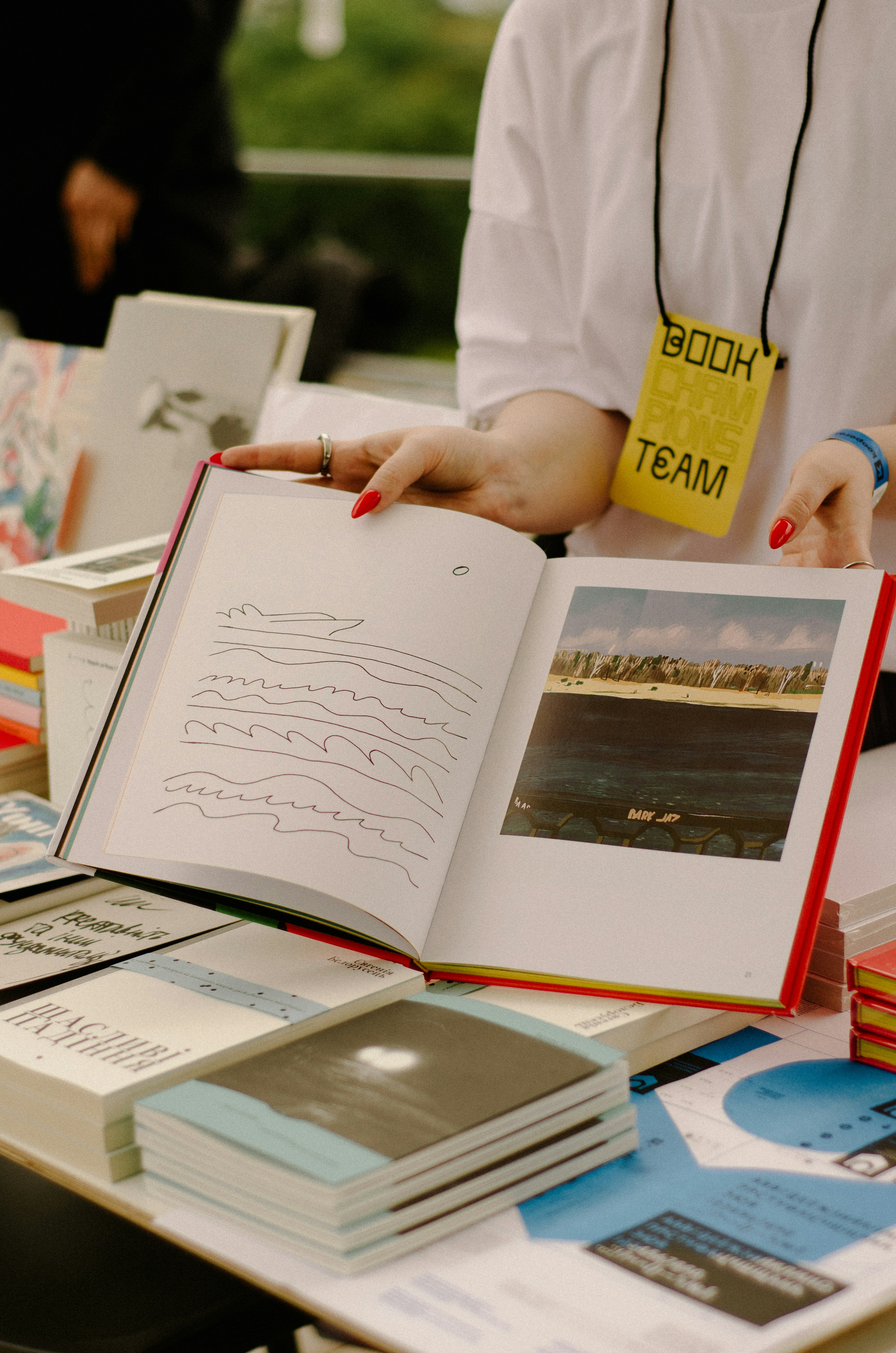 a person holding a book open on a table