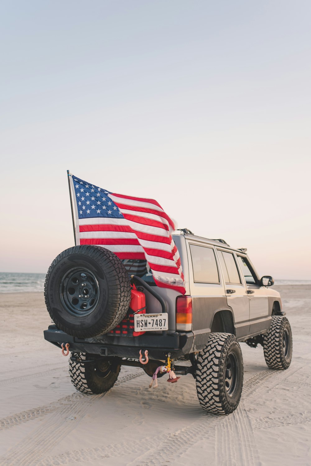 um jipe com uma bandeira americana na parte de trás dele