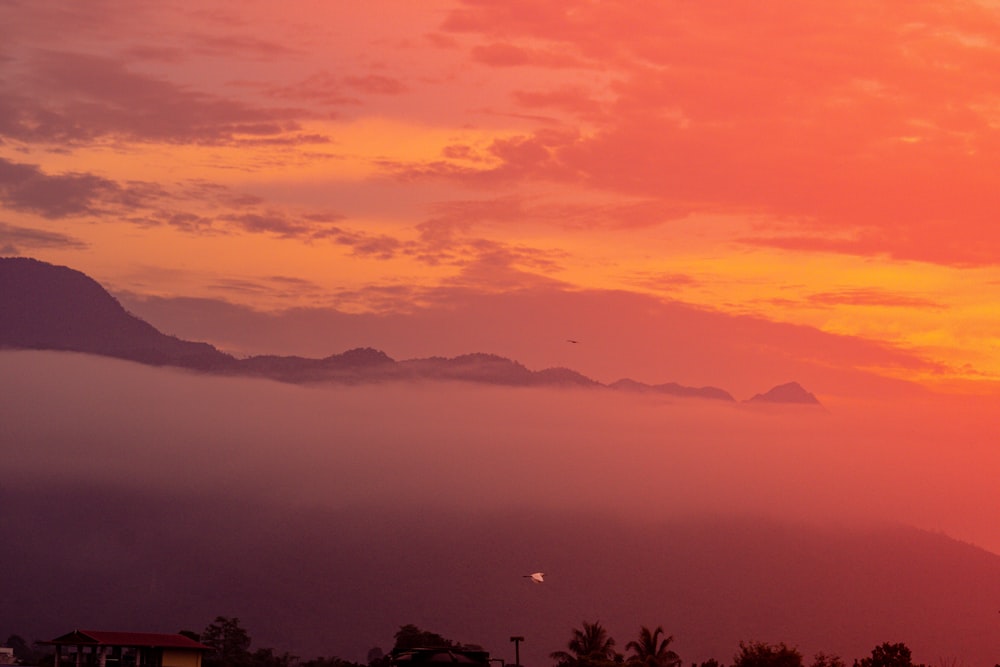 the sun is setting over a mountain range