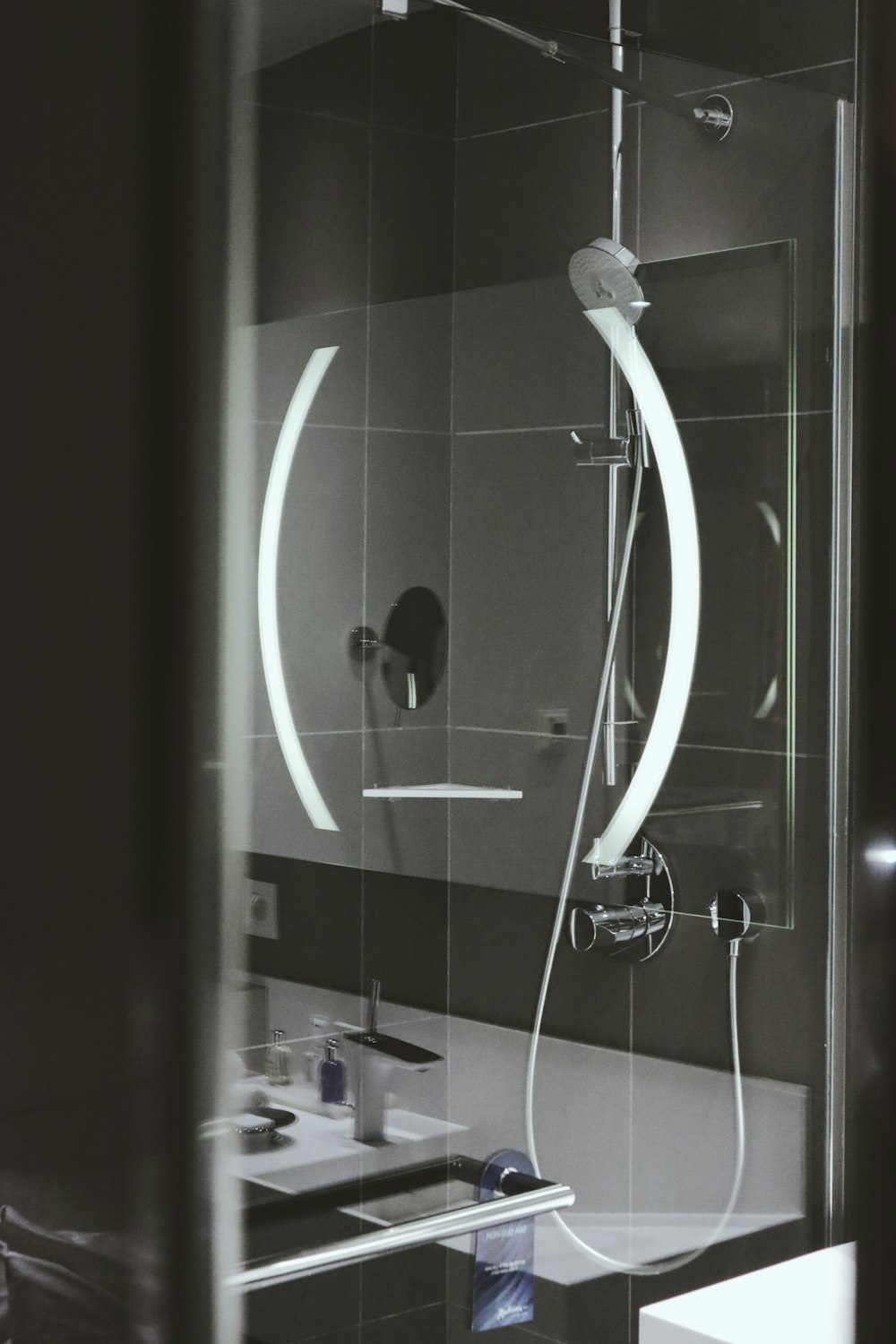 a bathroom with a sink, mirror and shower head