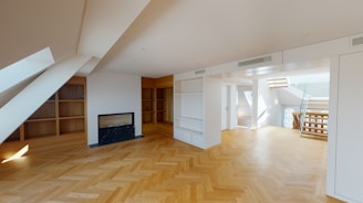 an empty room with a fireplace and shelves