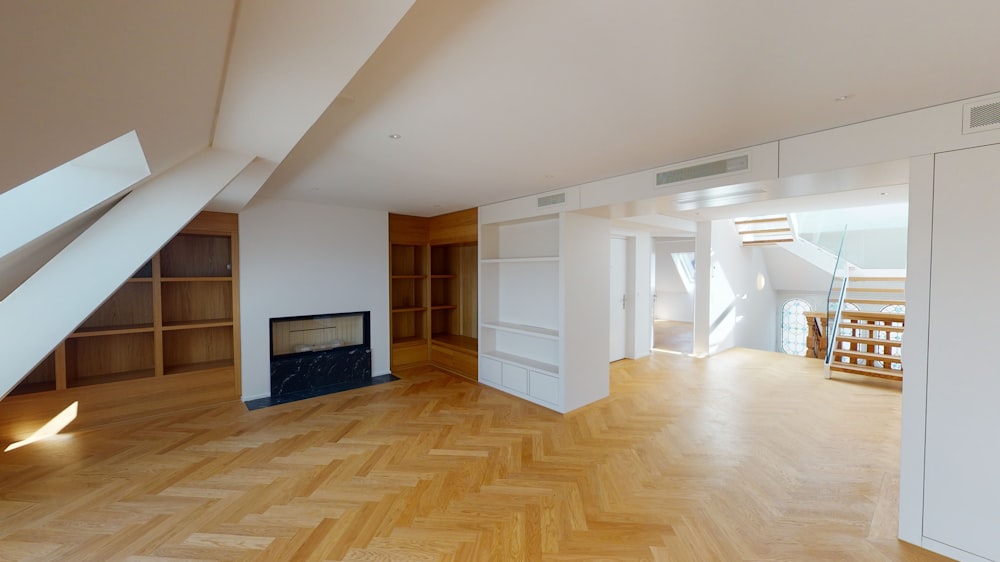 an empty room with a fireplace and shelves