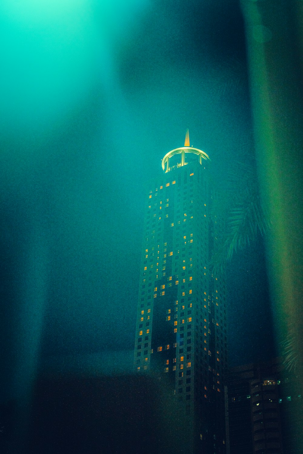 a tall building lit up at night in a city