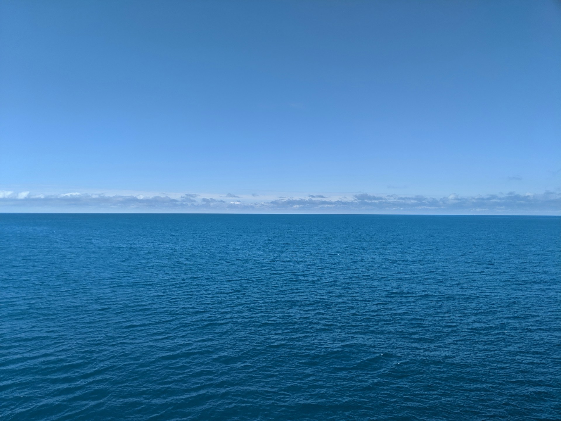 a large body of water sitting under a blue sky