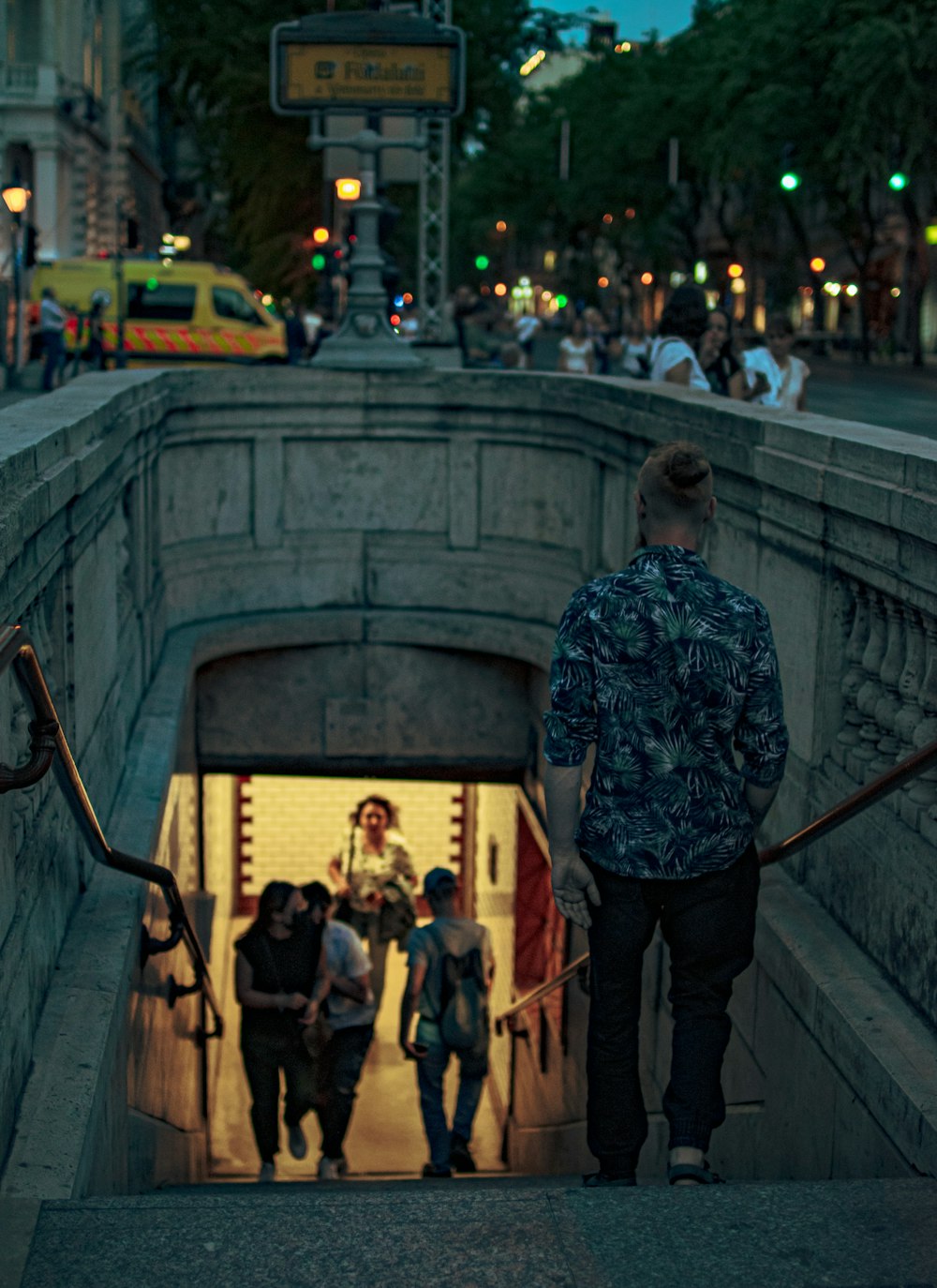 a group of people walking down a street next to a tunnel