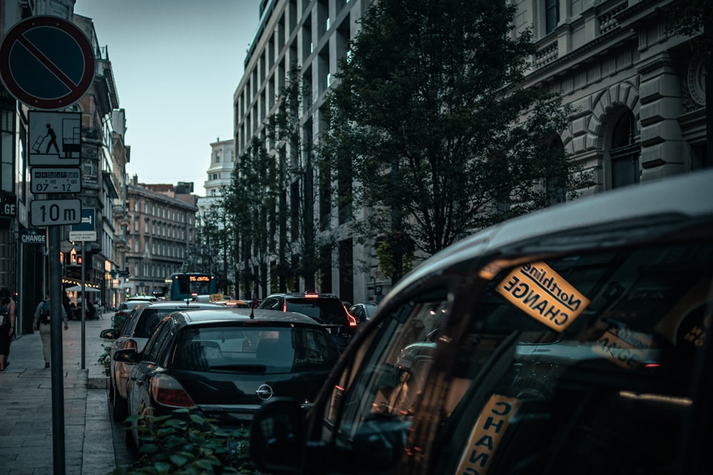 a city street filled with lots of traffic next to tall buildings