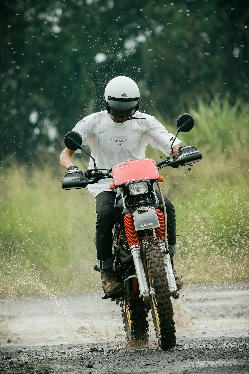 濡れた道でバイクに乗る男