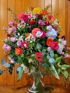 A beautiful floral arrangement featuring a variety of colorful flowers in a stylish vase.