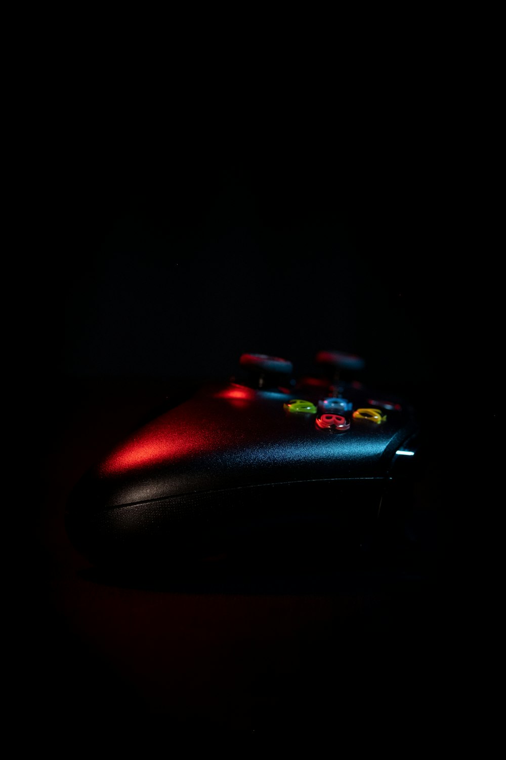 a close up of a video game controller in the dark